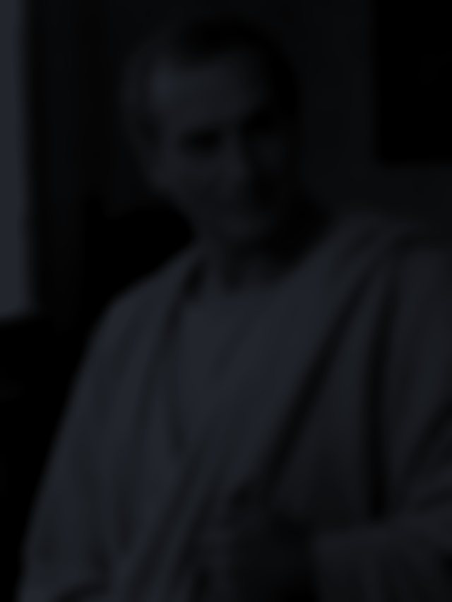 A man’s figure in deep shadow, his face unreadable